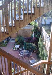The tri-level outside staircase provides a view of the backyard patio, gardens and area