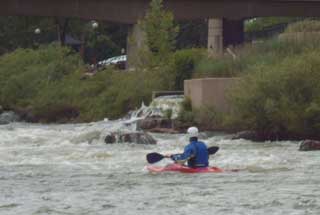 A kayaker makes his way amidst the rapids in downtown Denver